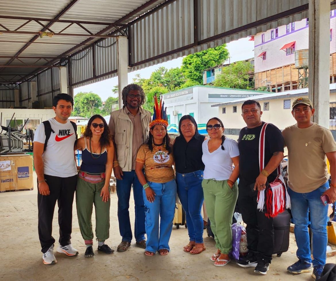 Integrantes da ACT-Brasil e lideranças indígenas, somando oito pessoas, posam juntas para foto. 