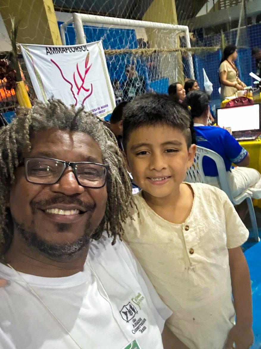 Luiz Lopes, diretor executivo da ACT-Brasil, e Pedro Kokama, jovem indígena de 7 anos, posam juntos para a foto. 