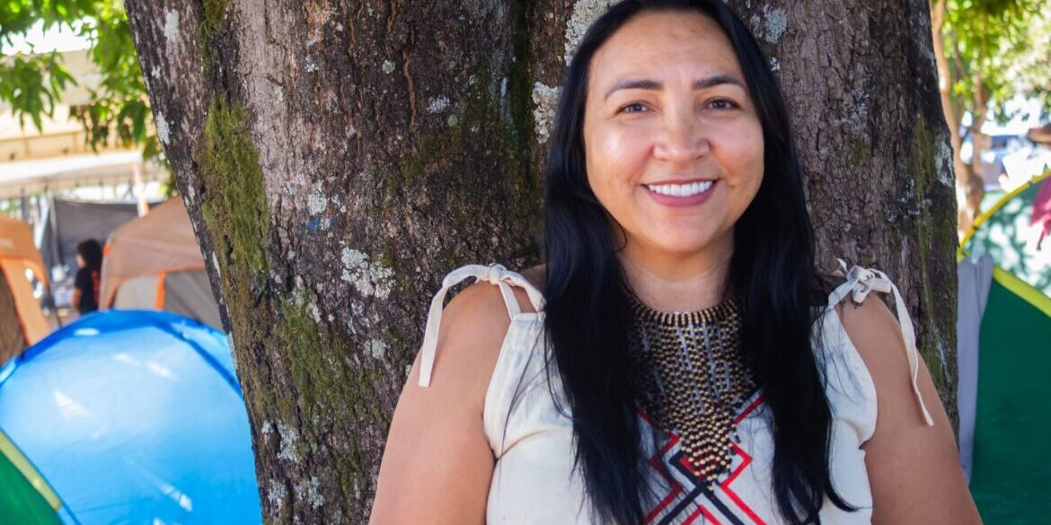 Retrato de Marilane sorrindo e  usando um vestido tradicional Kokama. Marilane tem cabelos longos, lisos e pretos e pele indígena.